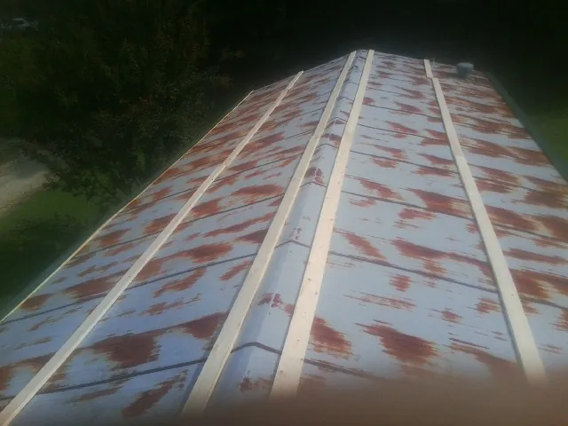 Rusted metal roof panels with new wood purlins before replacement — Storm Damage Roof Repair in Ihlen by Roofing Brothers