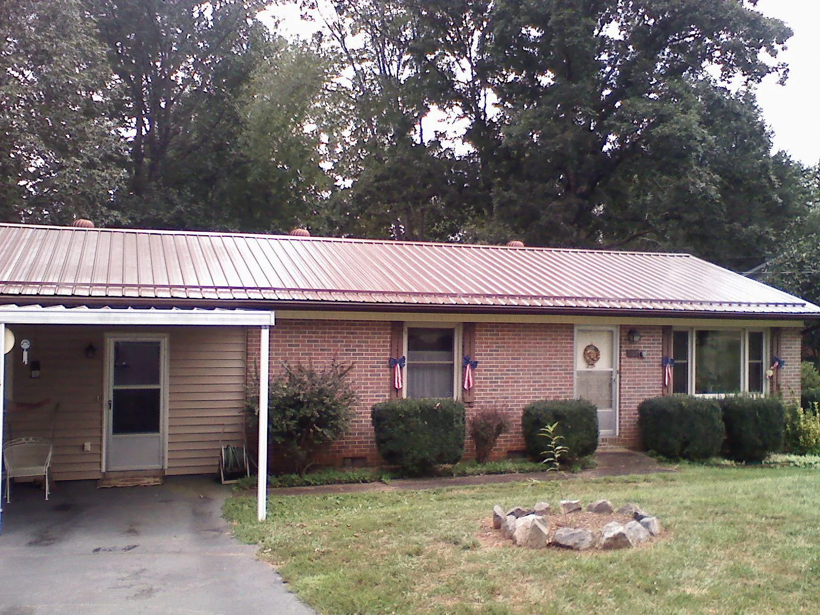 Bronze metal roof and carport on a brick ranch home — Roof Repair work by our crew in Ihlen